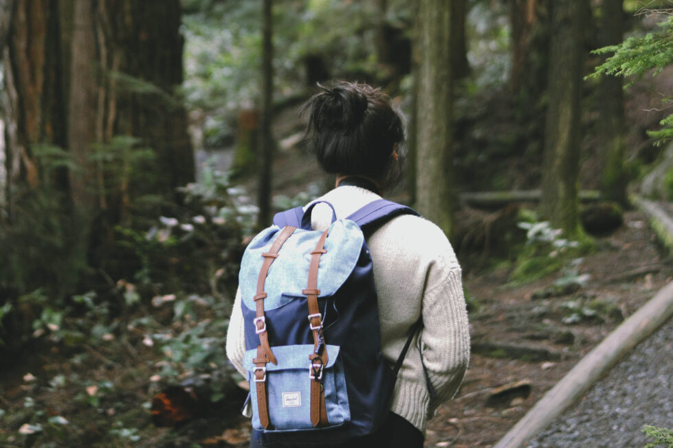 Woman walking in a serene forest experiencing nature therapy benefits such as stress relief, improved mood, and boosted immunity.